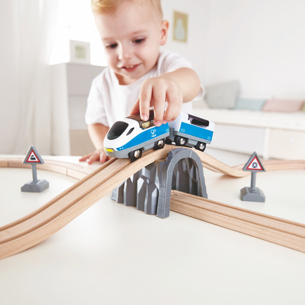 Passenger Train Set Hape, Young child playing with Hape wooden train set on the floor – hands-on learning toy in Kenya
