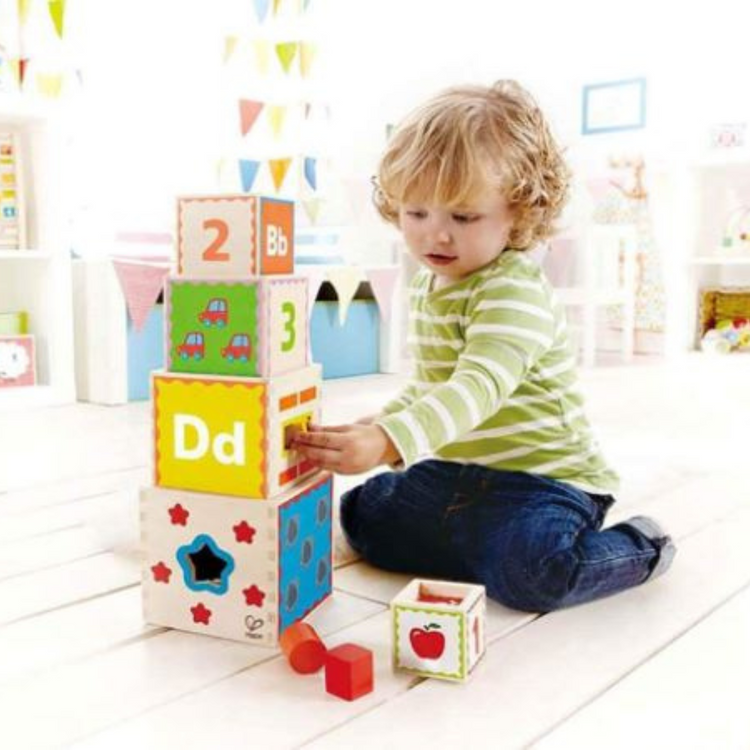 Child playing with Hape Pyramid of Play stacking and shape sorting toy