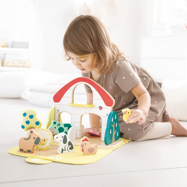 Children in Kenya playing with Hape Farm House wooden toy set for imaginative farm role play.