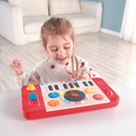Girl playing with Hape DJ Mix & Spin Musical Toy – fun interactive DJ set that helps develop rhythm and coordination, sold by Cheza Plus Kenya.